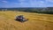 Modern harvest velhice combine tractor harvester harvests crops in the field, aerial fly orbit.