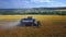 Modern harvest velhice combine tractor harvester harvests crops in the field, aerial fly orbit.