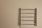 Modern heated towel rail on beige wall. Space for text