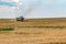 Modern heavy harvester removes the ripe wheat bread in field. Seasonal agricultural work