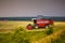 Modern heavy harvester removes the ripe wheat bread in field before the storm. Seasonal agricultural work