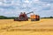 modern heavy harvesters remove the ripe wheat bread in field. Seasonal agricultural work