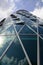 Modern highrise building seen from below; clouds reflecting in the glass facade