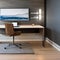 A modern home office with a floating desk, ergonomic chair, and sleek technology setup1
