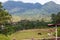 Modern horse stable and riding school in barn at farm with mountains and houses jungle in background