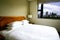 Modern hotel bedroom overlooking the cityscape.