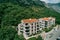 Modern hotel complex with parking at the foot of the green mountains. Drone