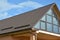 Modern house attic  metal tile roof with panoramic glass wall window and roof gutter