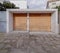 A modern house entrance with solid wood pedestrian and car doors