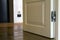 Modern house interior detail with wooden parquet floor and white door. Apartment after renovation close-up.