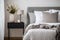 Modern house interior details. Simple cozy bedroom interior with gray bed headboard, linen bedding, bedside table and