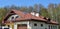 Modern house rooftop panorama with red clay roof tiles,  roof skylights and solar water heaters panels