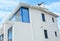 Modern house with white wall, glass balcony, terrace, rain gutter