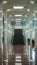 Modern indoor space with shiny corridor, stairs, seating area, square lights, marble floor