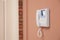 Modern intercom system with handset on beige wall, space for text