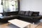 Modern interior of living room with comfortable black leather sofa