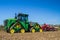 Modern john deere caterpilla tractor cultivating English crop field