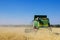 Modern John Deere combine harvesting grain in the field