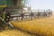 Modern John Deere combine harvesting grain in the field