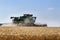 Modern John Deere combine harvesting grain in the field