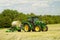 Modern John Deere green tractor with round bale wrapper