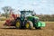 Modern John Deere tractor drilling seed in field