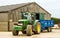 Modern John Deere tractor parking blue trailer