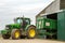 Modern John Deere tractor parking green trailer