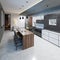 Modern kitchen design with a long center island and bar table fitted with a black marble countertop, stainless steel equipment