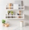 Modern kitchen featuring white shelving and greens, adding a touch of greenery to the interior