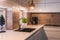 Modern kitchenette with white worktop, black sink and metal lamps