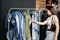 Modern Latina young woman choosing 100 percent organic cotton wear in modern eco-friendly showroom.