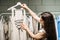 Modern Latina young woman choosing 100 percent organic cotton wear in modern eco-friendly showroom.