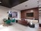 Modern living room combined with dining room. Wall mounted tv unit stand on a wooden wall made of planks. Green, burgundy, brown,