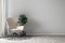 Modern living room interior mockup in minimalist style with chair, rug and plant decoration on empty warm neutral wall background.