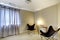 Modern living room interior with two black chairs and beige carpet.