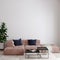 Modern livingroom with pink sofa and blue pillows in front of the empty wall  interior wall mockup