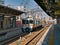 A modern, local, electric commuter train at an empty platform at Nagoya Station on a bright, sunny morning in November