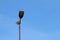 Modern lonely tall street light and bright blue sky