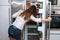 Modern long haired woman standing in the kitchen and open refrigerators door and looking inside.