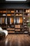 Modern, luxury brown built-in wardrobe for a man in the bedroom, shelves with men\\\'s clothing.