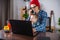Modern man is working on a laptop, and his little son is sitting on his lap. Concept of family and remote work from home