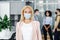 Modern manager returns to work after quarantine. Focus on attractive blonde woman in protective mask and business suit