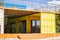 Modern metal building house made from shipping yellow containers on the beach and blue sky background