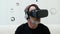 Modern middle-aged man with grey beard puts on wireless headphones and use VR headset