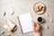 Modern minimal home workspace desk with human hand writing text message on blank paper notebook, waffles, dry flowers on concrete