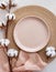 Modern minimal table place setting neutral peach fuzz color top view decorated with flowers cotton branch. Space for text or menu