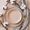 Modern minimal table place setting neutral peach fuzz color top view decorated with flowers cotton branch. Space for text or menu