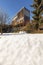 Modern minimal wooden house exterior. The season is winter and therefore you can see the snow in the garden