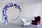 Modern minimalism interior. Flower decorated chair with leather armchair in white room.